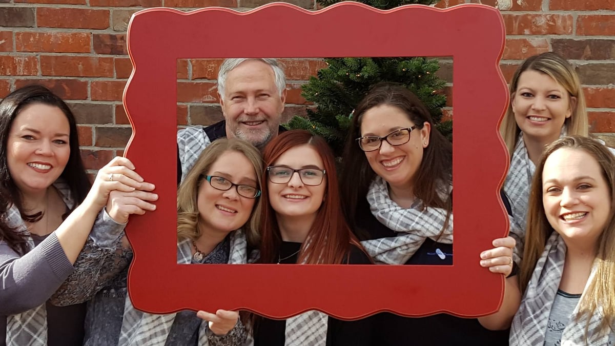McLoud Clinic Pharmacy team posing together with a red picture frame